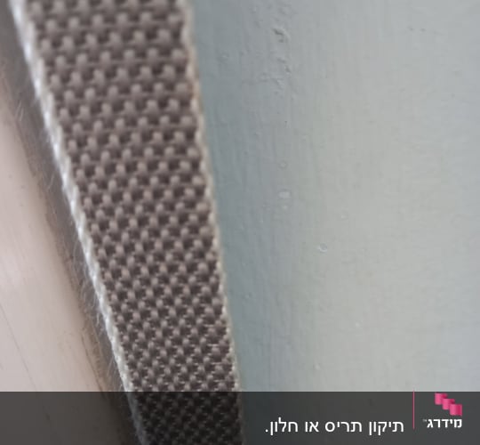 רצועת תריס חומה על רקע קיר בהיר
